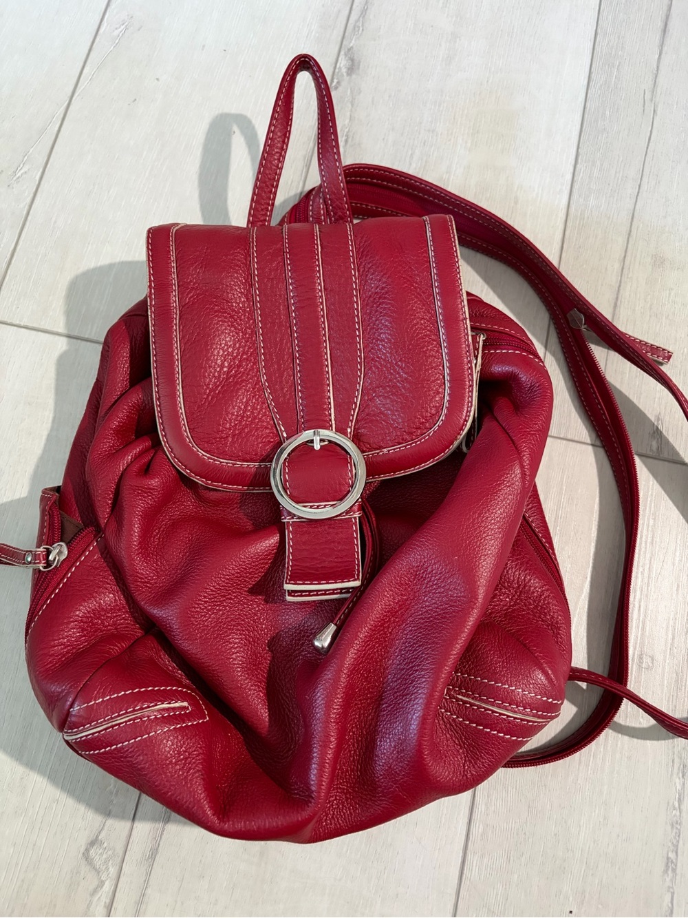 Red leather backpack with white stitching